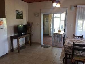 a room with a kitchen and a living room with a television at La casa de Yayo in Villa Giardino