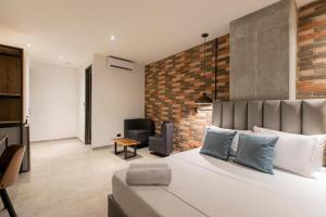 a bedroom with a large bed and a brick wall at Apartahotel Medellin in Medellín