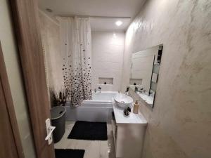 ein weißes Badezimmer mit einer Badewanne und einem Waschbecken in der Unterkunft Dominic house in Turda