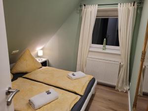 StruckumにあるFerienhaus Windの小さなベッドルーム(ベッド2台、窓付)