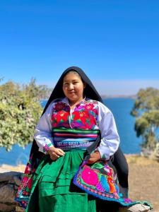 a woman in a colorful dress posing for a picture at Arco Wasi Hospedaje Amantani in Puno