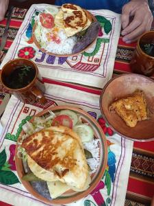 Arco Wasi Hospedaje Amantani في بونو: طاولة عليها طبقين من الطعام