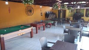 un restaurante con mesa de billar, mesas y sillas en Encantos de Canedos en Piracaia