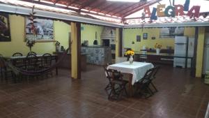 Zimmer mit einem Tisch und Stühlen sowie einer Küche in der Unterkunft Encantos de Canedos in Piracaia