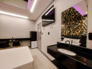 uma casa de banho com um lavatório e um espelho em Único Motel Faria Lima em São Paulo