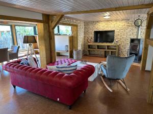 un soggiorno con divano rosso e TV di Strandhaus Möve a Dierhagen