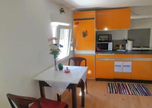 una cocina con una mesa blanca y armarios naranjas en APARTMENTS / WOHNUNG IN HAIBACH, en Haibach