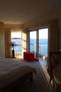 a hotel room with a bed and a view of the ocean at C'est la vie, and a view. in Cape Town