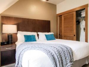 a bedroom with a large white bed with blue pillows at Hyatt Residence Club Main Street Station in Breckenridge +26 photos