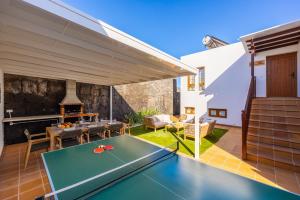 a patio with a ping pong table and a fireplace at Villa Saona in Playa Blanca