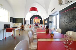 un ristorante con tavoli e sedie rossi e bianchi di Camere a Sud ad Alliste