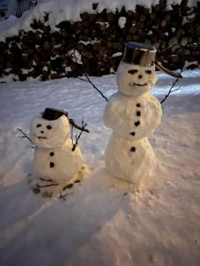 Twee sneeuwmannen staan in de sneeuw bij Willa WIKTORIA in Krynica Zdrój