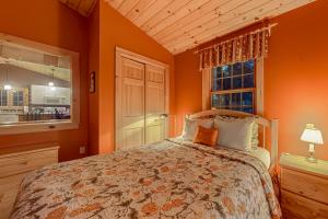 a bedroom with a bed with orange walls and a window at The Loft at Pine Rock in Weston