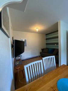 sala de estar con mesa, sillas y TV en Charmig liten lägenhet på Österlen en Sankt Olof