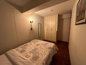Lugar acogedor, céntrico:3H,WIFI في كوسكو: غرفة نوم صغيرة مع سرير وخزانة