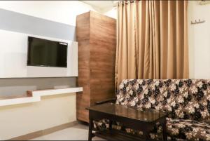 - un salon avec un canapé et une télévision dans l'établissement Menaka, à Vijayawada