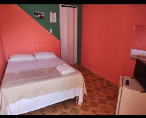 um quarto com paredes vermelhas e verdes e uma cama em Pousada Aconchego em Salinópolis