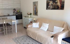 a living room with a couch and a kitchen at affitto appartamento sul mare in Senigallia