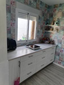 Una cocina con encimera con fregadero y ventana. en Cabaña EL SALTO DEL DUENDE, en Carrión de los Céspedes