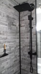 La salle de bains est pourvue d'une douche et d'un mur en briques. dans l'établissement joli appartement T2 très bien situé, parking couvert, à Lourdes