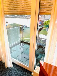 d'une porte coulissante en verre avec vue sur un balcon. dans l'établissement Hotel Garni Merkenich, à Cologne