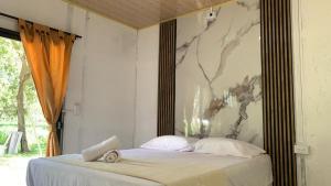 een slaapkamer met een bed met een schilderij aan de muur bij Los Potrillos in Mariquita