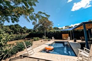 a swimming pool in a yard with chairs and a house at Casa El Sueño in Brasilito