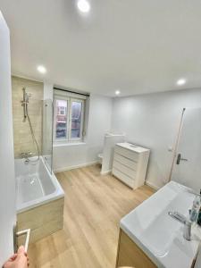 ein Bad mit einer Badewanne, einem Waschbecken und einer Dusche in der Unterkunft Maison familiale 3 chambres avec terrasse in Mouvaux