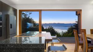 a kitchen with a table and a view of the ocean at Sunset Haven in Nelson in Nelson