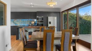 a kitchen and dining room with a table and chairs at Sunset Haven in Nelson in Nelson +13 photos