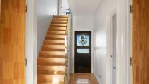 a staircase in a house with white walls and wooden floors at Sunset Haven in Nelson in Nelson