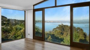 a room with large windows looking out at the water at Sunset Haven in Nelson in Nelson