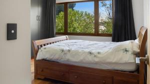 a bedroom with a bed in front of a window at Sunset Haven in Nelson in Nelson