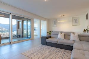 a living room with a couch and a large window at IMPERIAL of LUGANO apartment-behind the station with FREE parking in Lugano