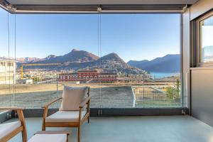 a room with a large window with a view of the city at IMPERIAL of LUGANO apartment-behind the station with FREE parking in Lugano