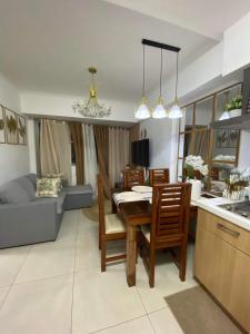 a kitchen and living room with a table and chairs at The Residences at Commonwealth by Century in Manila