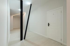 a mirror in a white room with a door at Smart hotel apartment with panoramic city view in Diplomat Hall in Kyiv