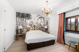 1 dormitorio con 1 cama y un mural de palmeras en Hotel Torenhof, en Sint-Martens-Latem