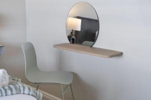 a mirror on a wall with a chair and a lamp at Witsand 102 by HostAgents in Bloubergstrand