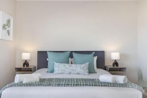 a bedroom with a large bed with blue pillows at Witsand 102 by HostAgents in Bloubergstrand