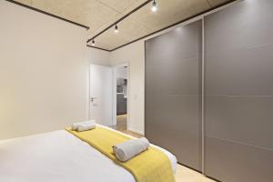 a bedroom with a bed with a yellow blanket at Bridgewater View 502 by HostAgents in Cape Town