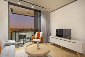 a living room with a tv and a couch and a table at Bridgewater View 502 by HostAgents in Cape Town