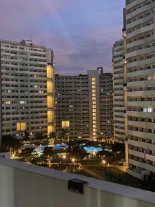 a view of a city at night with tall buildings at The Residences at Commonwealth by Century in Manila