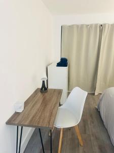 uma mesa de madeira e uma cadeira branca num quarto em Hemel Apartments- City Zen em Hemel Hempstead