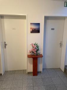 科隆的住宿－Hotel Garni Merkenich，走廊上设有两扇门,桌子上摆放着鲜花