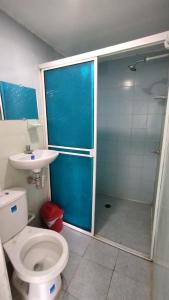 a bathroom with a toilet and a shower and a sink at Hostal La Casa De Mamá in Arboletes