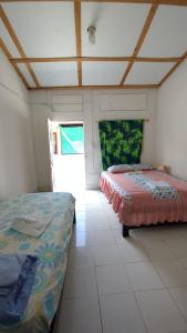a bedroom with two beds in a room at Hostal La Casa De Mamá in Arboletes