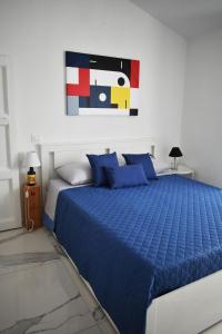 a bedroom with a blue bed with a painting on the wall at Casa Vacanze La Dimora di Santa Barbara in Petralia Soprana