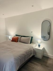 um quarto com uma cama com um espelho na parede em Hemel Apartments- City Zen em Hemel Hempstead
