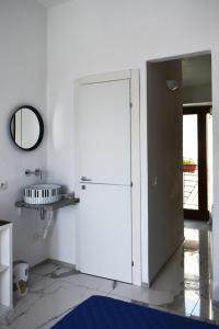 Casa Vacanze La Dimora di Santa Barbara في بيتراليا سوبرانا: باب أبيض كبير في غرفة مع مرآة